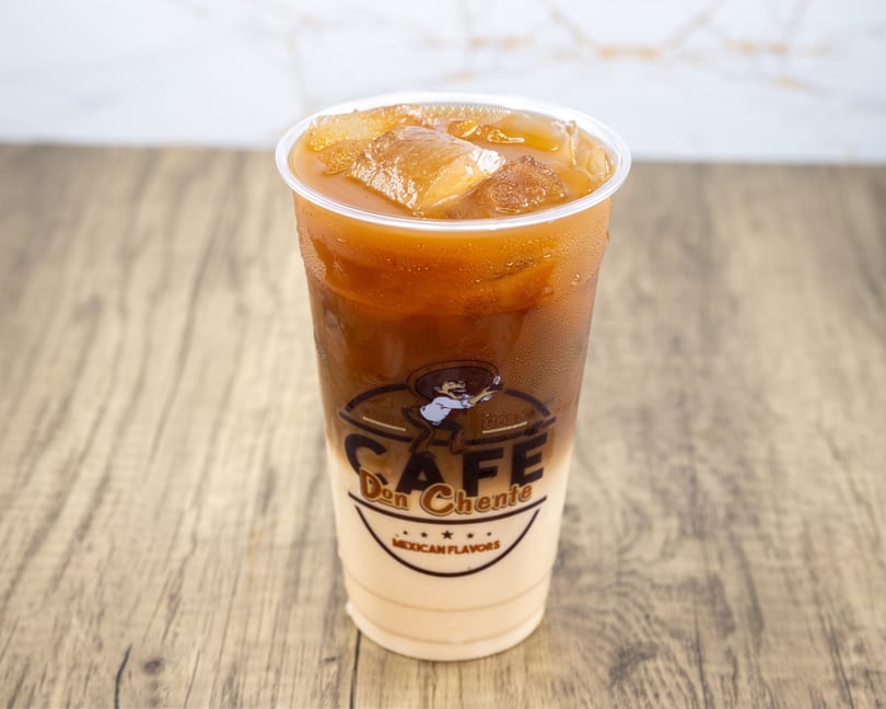 Iced coffee with milk in a clear plastic cup with the "Cafe Don Chente Mexican Flavors" logo.